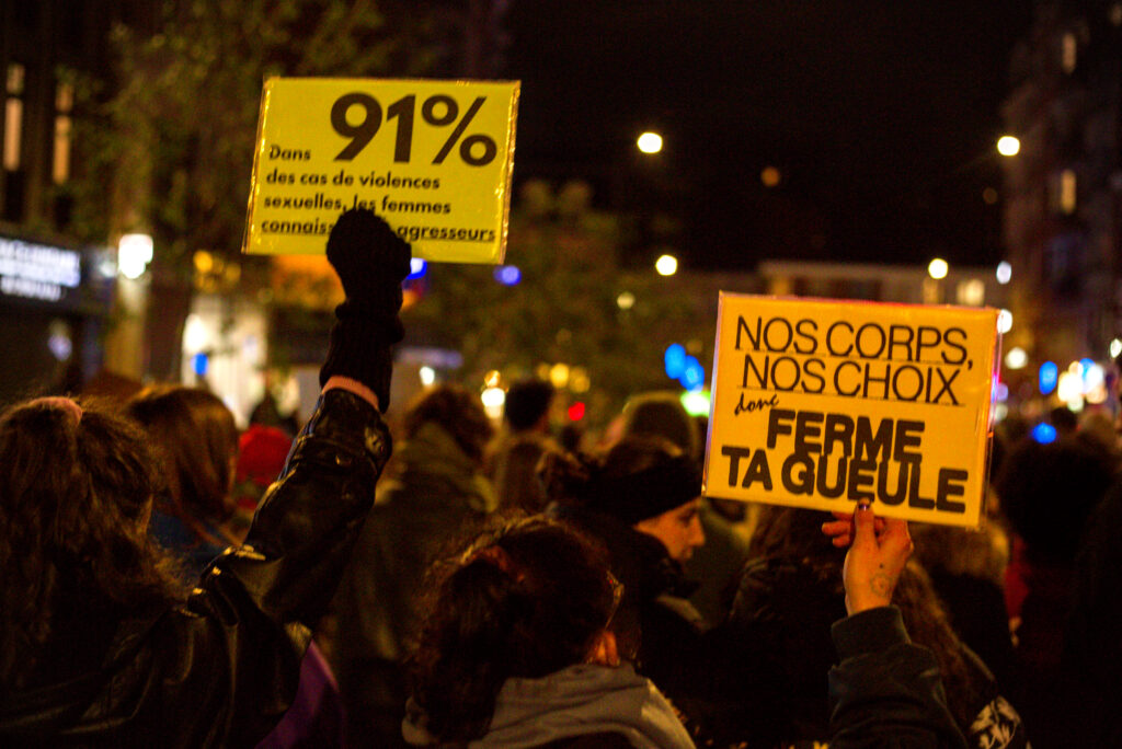 Pancartes "Dans 91% des cas de violences sexuelles, les femmes connaissent leurs agresseurs", et "Nos corps, nos choix, donc ferme ta gueule".