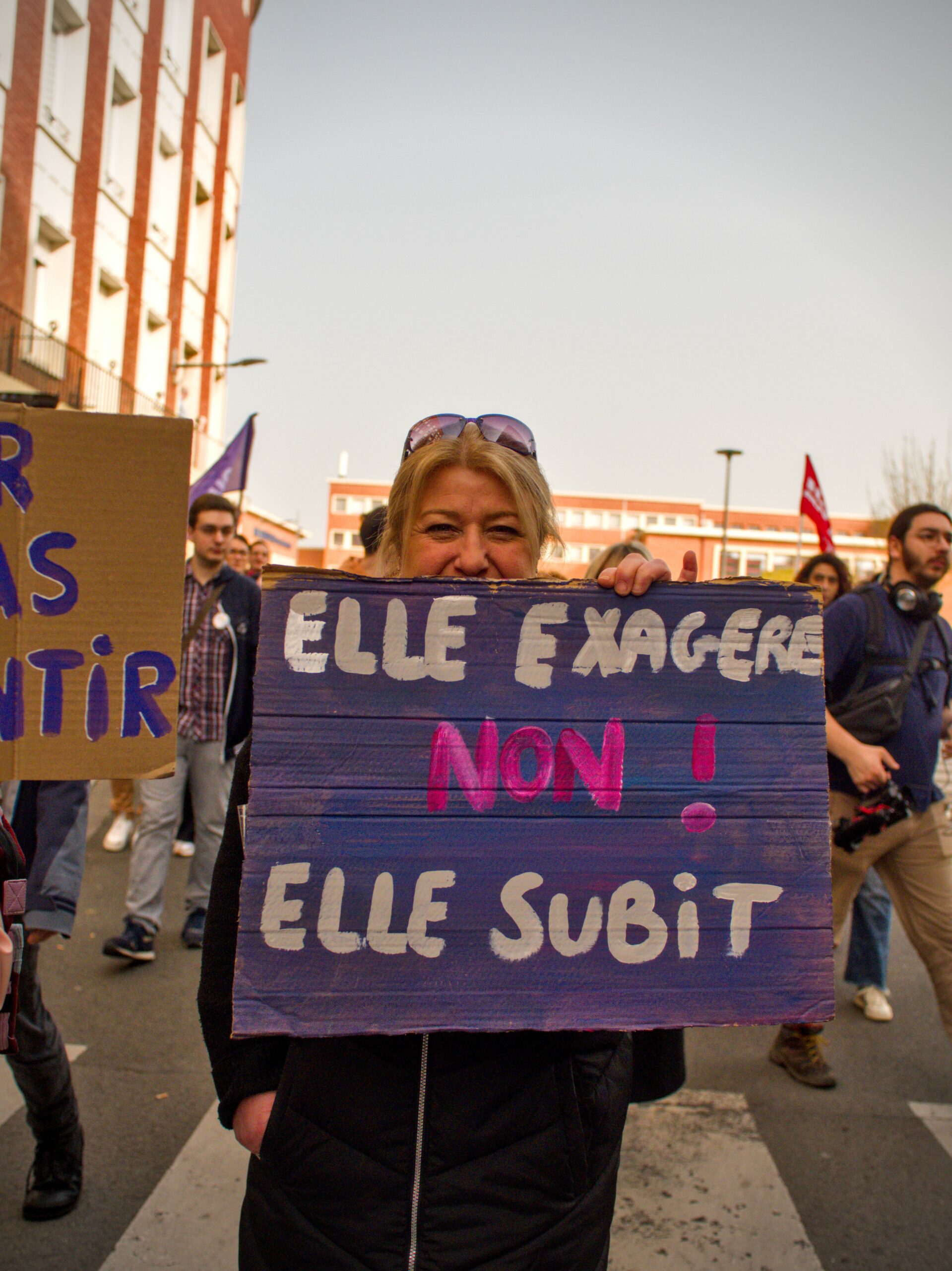 Une manifestante tient une pancarte "Elle exagère. Non ! Elle subit."