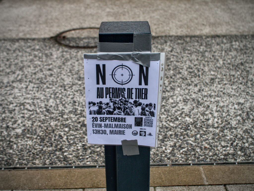 Affiche collée sur un poteau de route : "Non au permis de tuer. 20 Septembre, Évin-Malmaison, 13h30, Mairie."