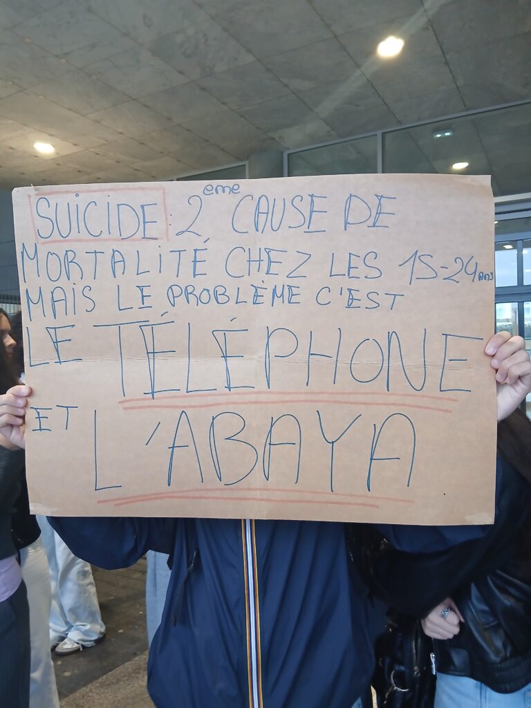 Pancarte : "Suicide, 2eme cause de mortalité chez les 15-24 ans, mais le problème c'est le téléphone et l'abaya".