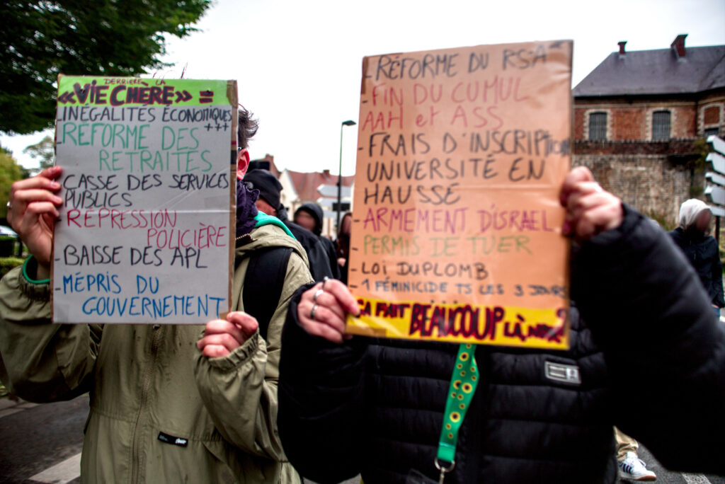 Deux pancartes :

Une, à gauche : "Derrière la vie chère : Inégalités économiques, réforme des retraites, casse des services publics, répression policière, baisse des APL, mépris du gouvernement".

A droite : "Réforme du RSA, fin du cumul AAH et ASS, frais d'inscription université en hausse, armement d'Israël, permis de tuer, loi duplomb, 1 féminicide tous les 3 jours... Ca fait beaucoup là, non ?"