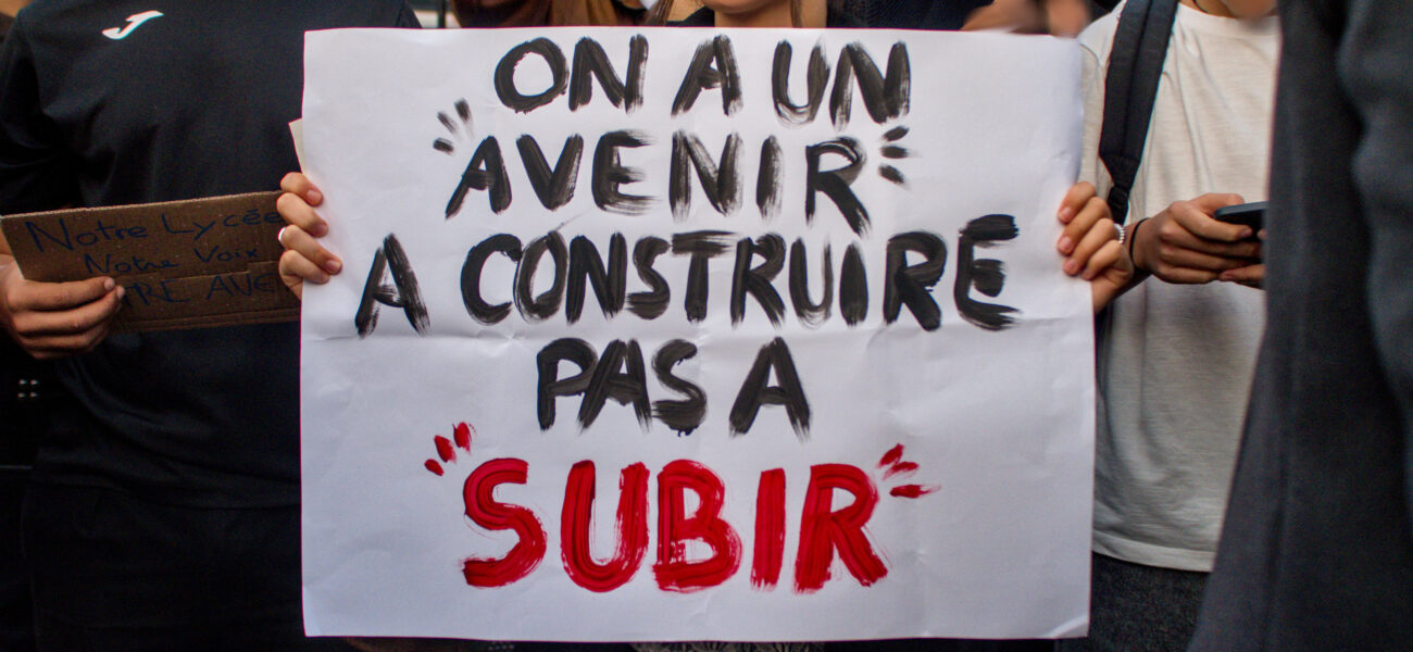 Une élève porte une pancarte "On a un avenir à construire, pas à subir"