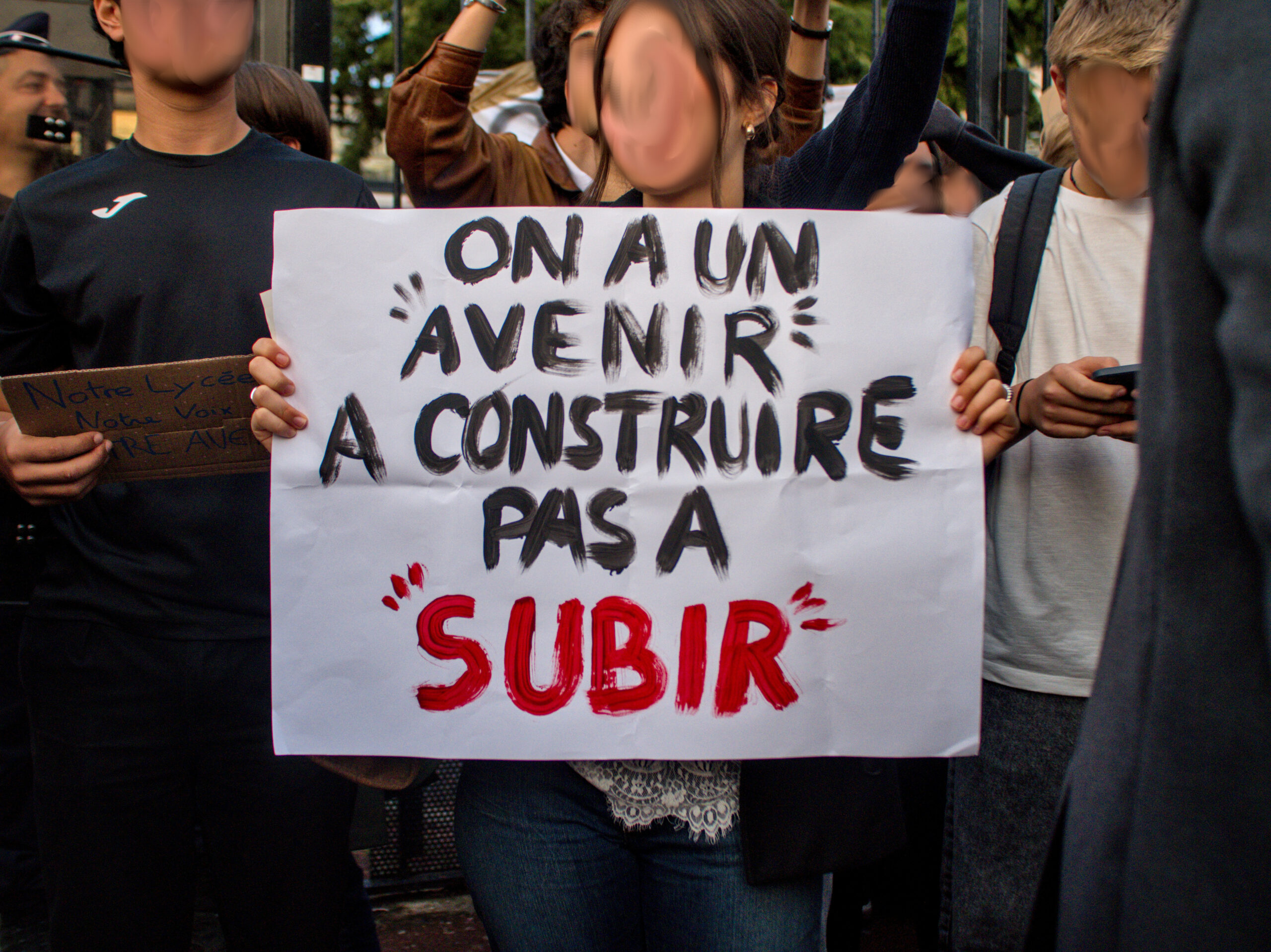 Une élève porte une pancarte "On a un avenir à construire, pas à subir"